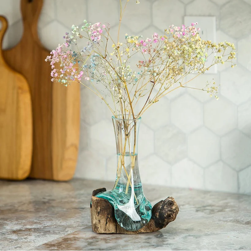 Jarrón de flores de vidrio soplado sobre madera de chinaberry
