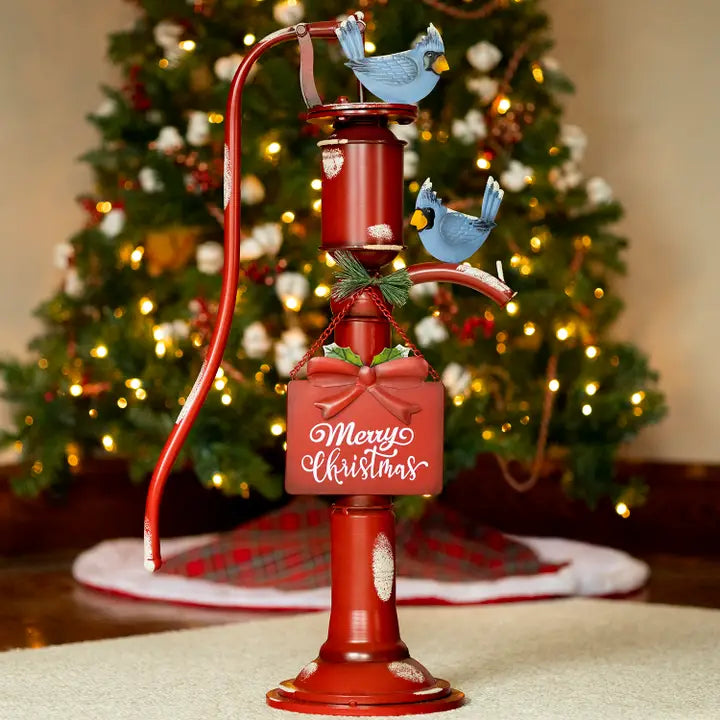 Bomba de agua de hierro rojo de estilo antiguo con letrero de "Feliz Navidad"