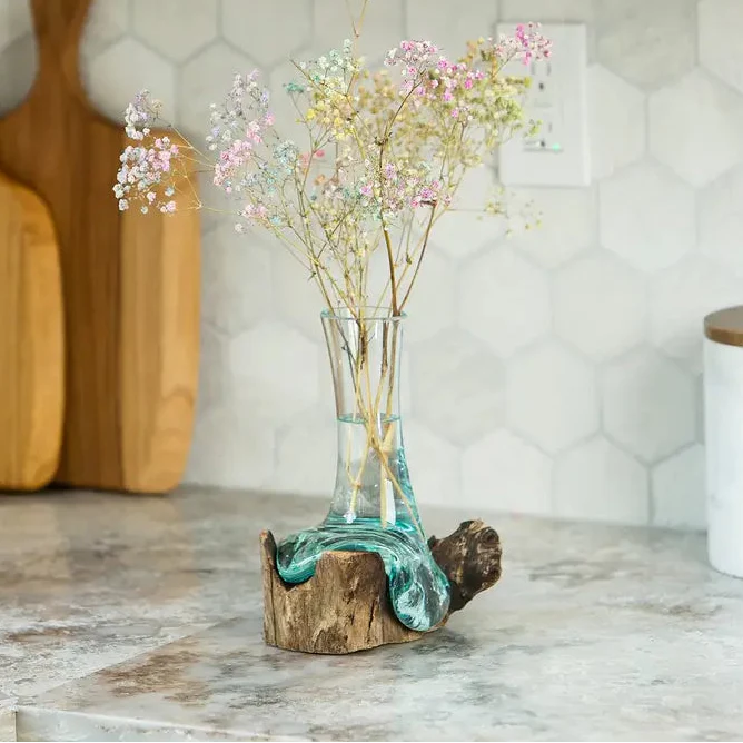 Jarrón de flores de vidrio soplado sobre madera de chinaberry