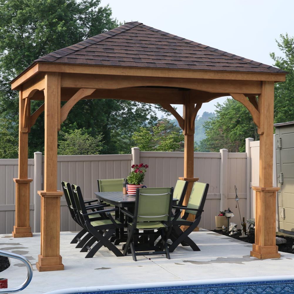 Wooden gazebo with a table and chairs near a pool